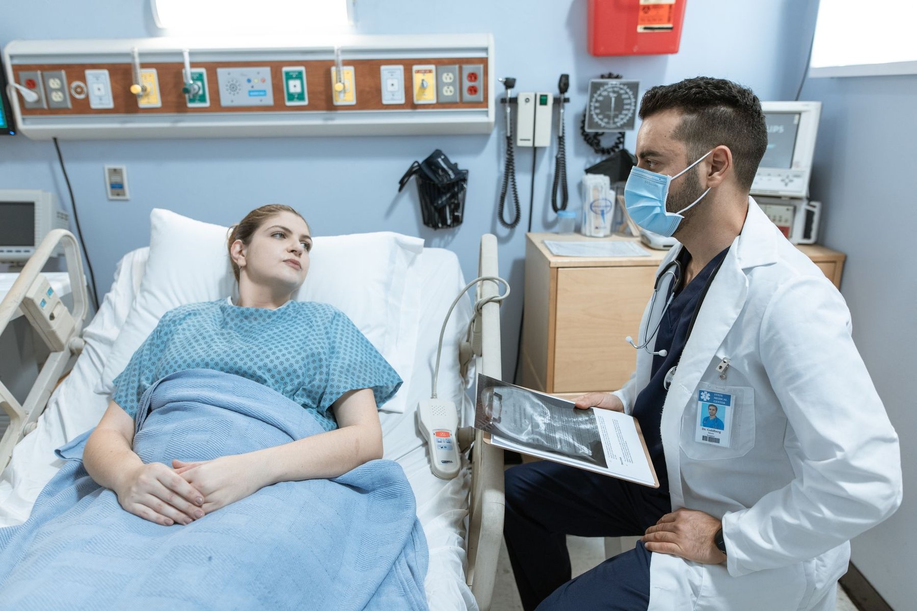 Doctor reviewing medical results with a seated hospital patient during a discharge discussion