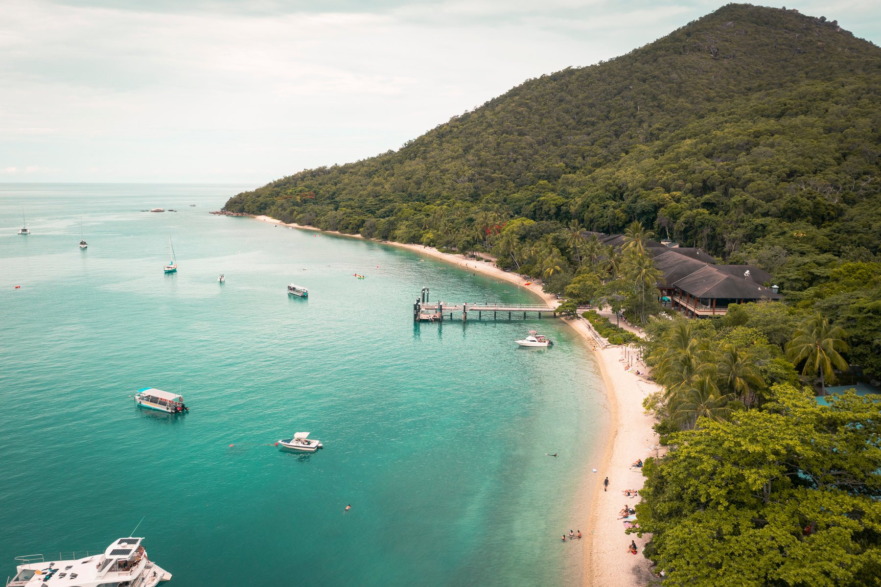 Aerial view of a tropical Far North Queensland coastline near Cairns, with turquoise waters and lush rainforest, representative of the Cape York region